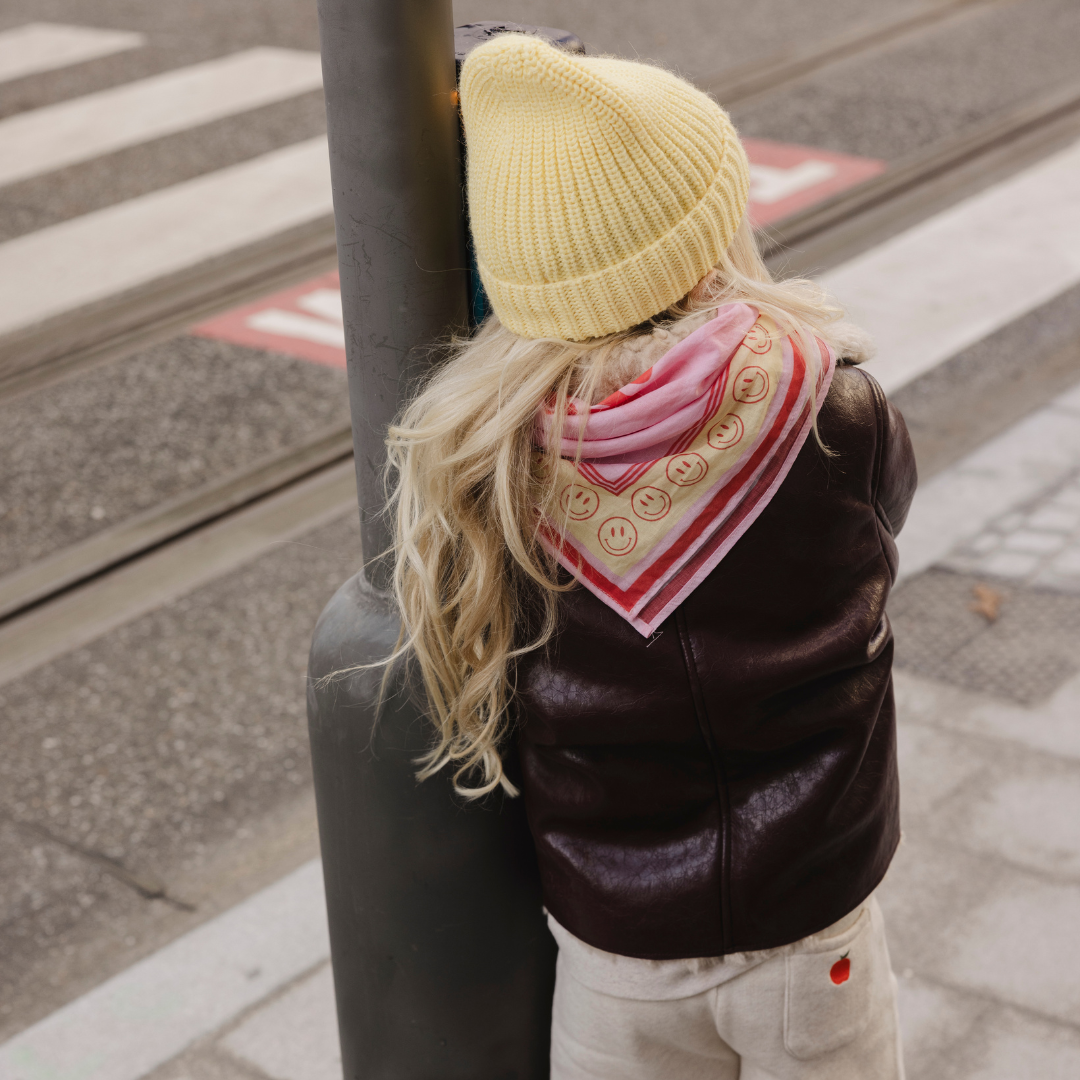 Een scarf in het roze met smileys en een tekst erop