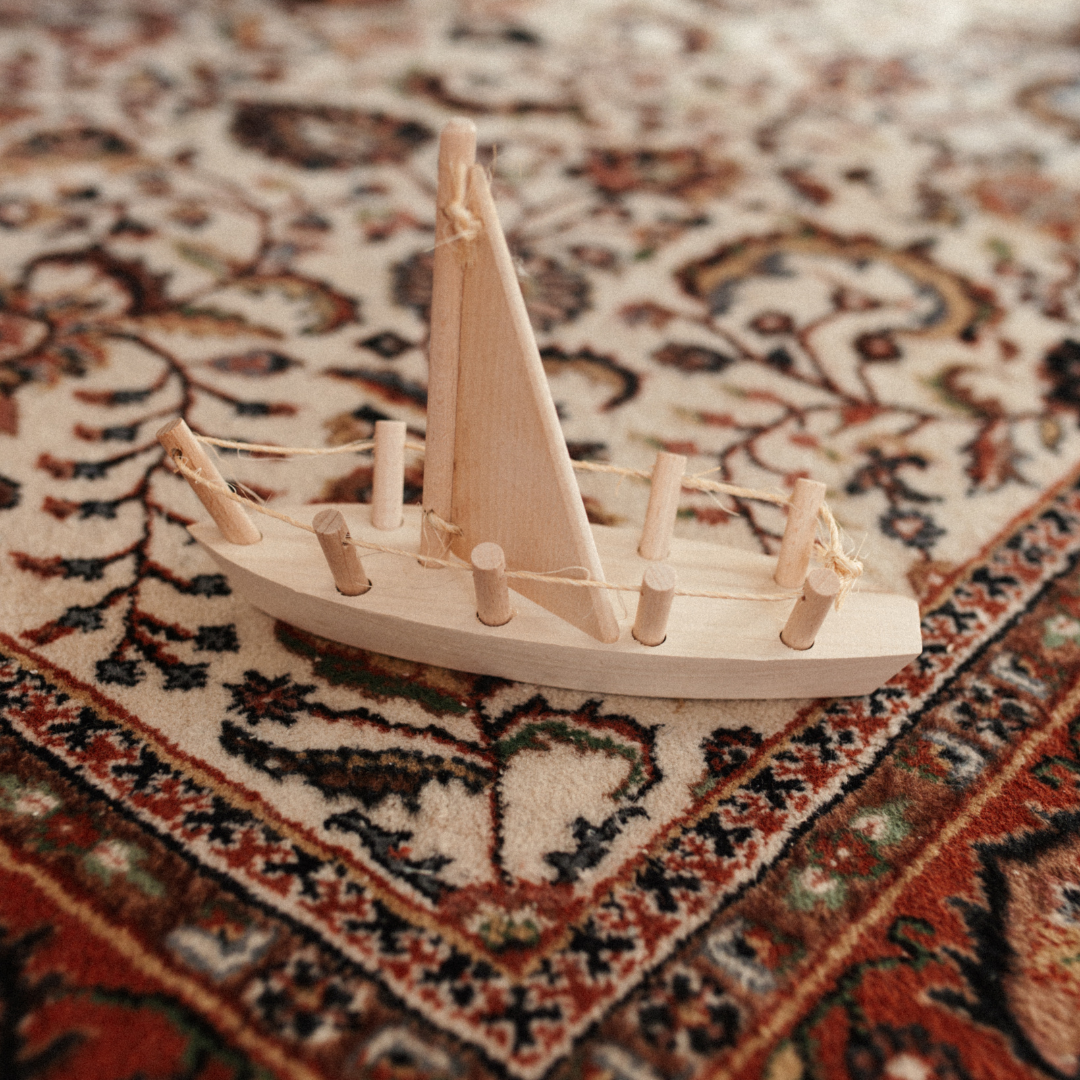 houten speelgoed zeilboot op een vloerkleed