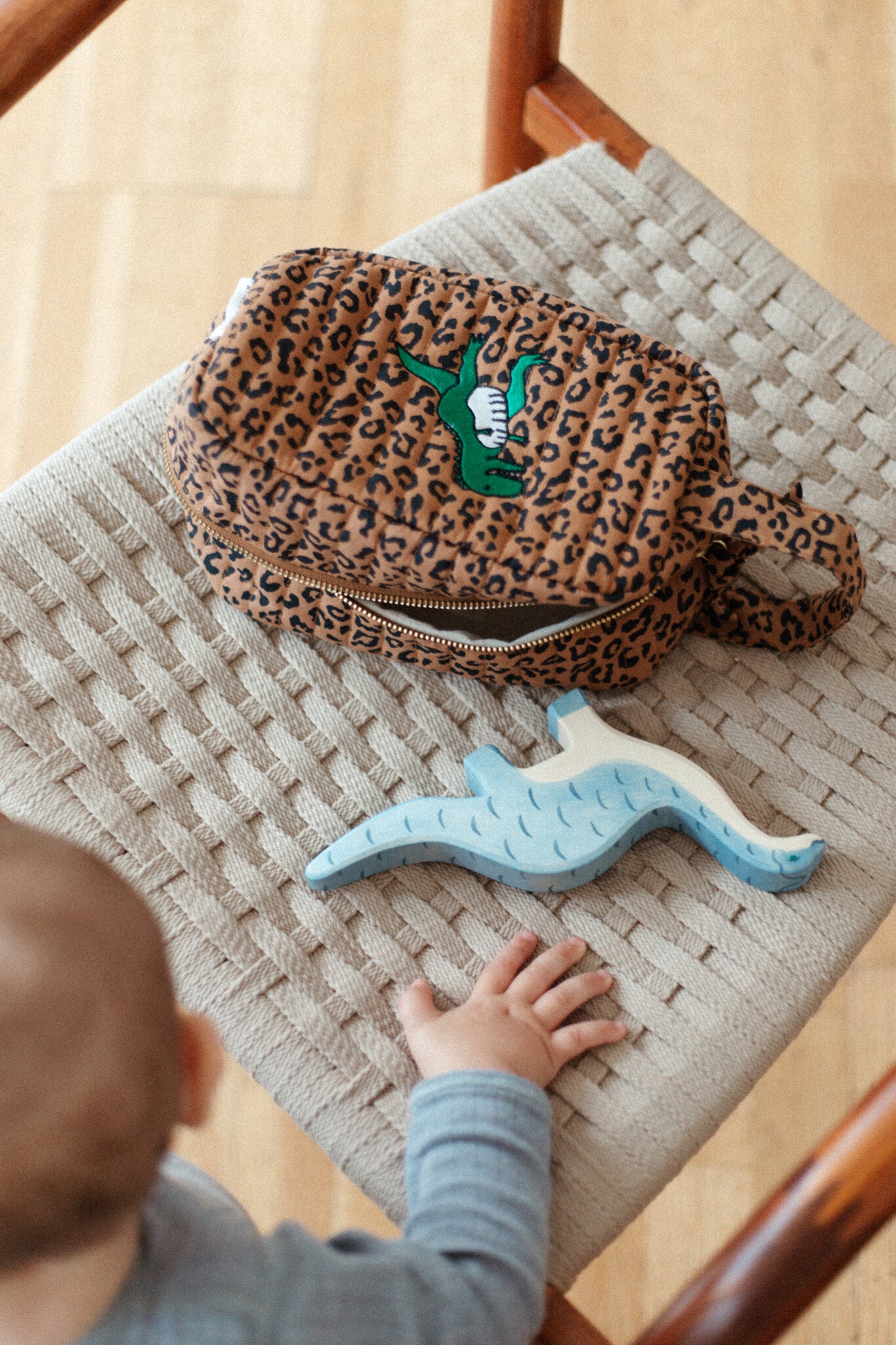 pouch voor moeders met baby in panterprint met een dino erop geborduurd