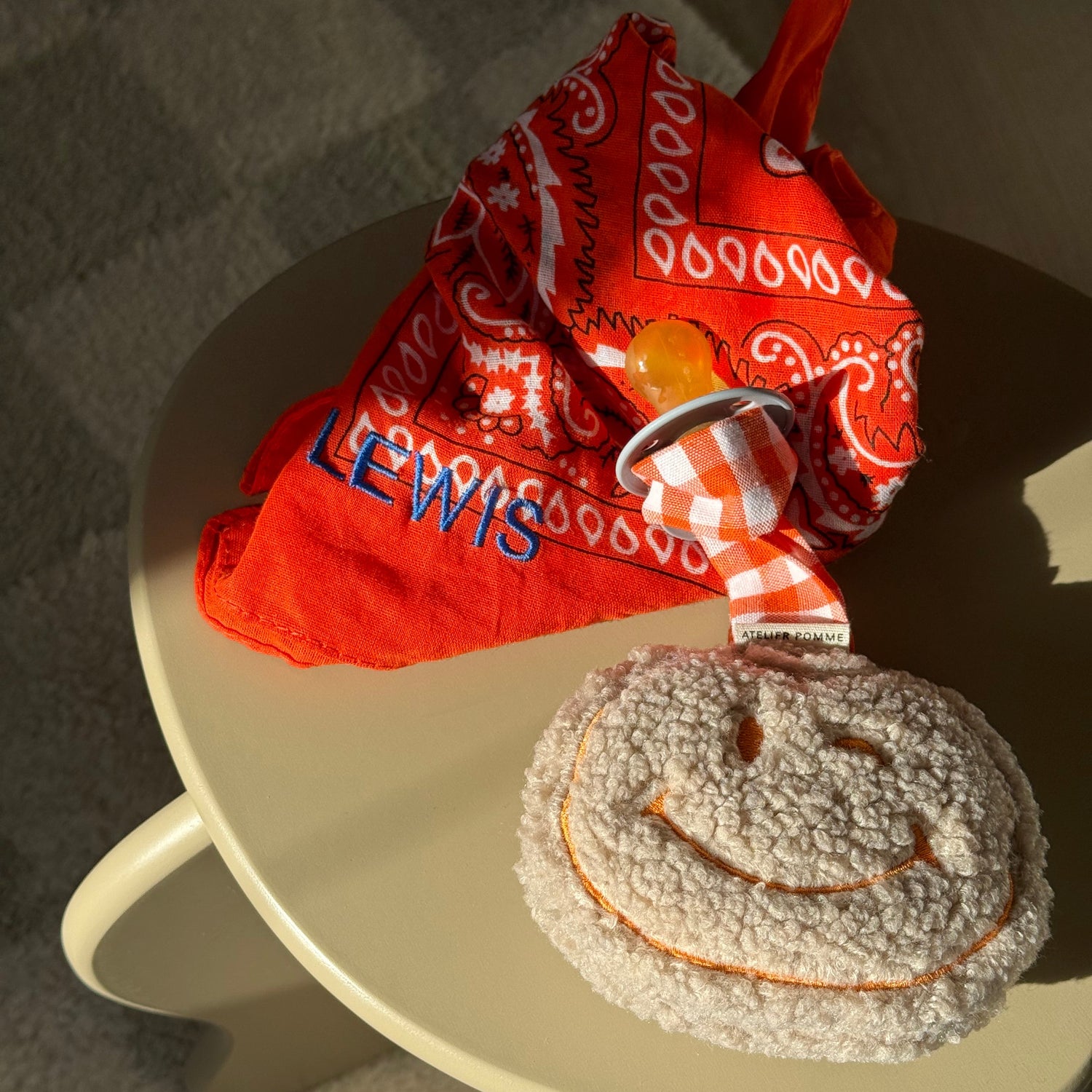 oranje bandana en pomme liggend op kruk