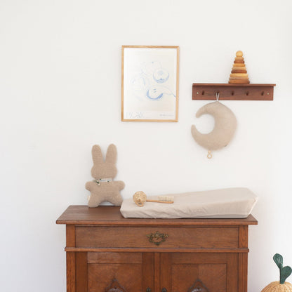Commode met aankleedkussen, rammelaar en knuffel. 