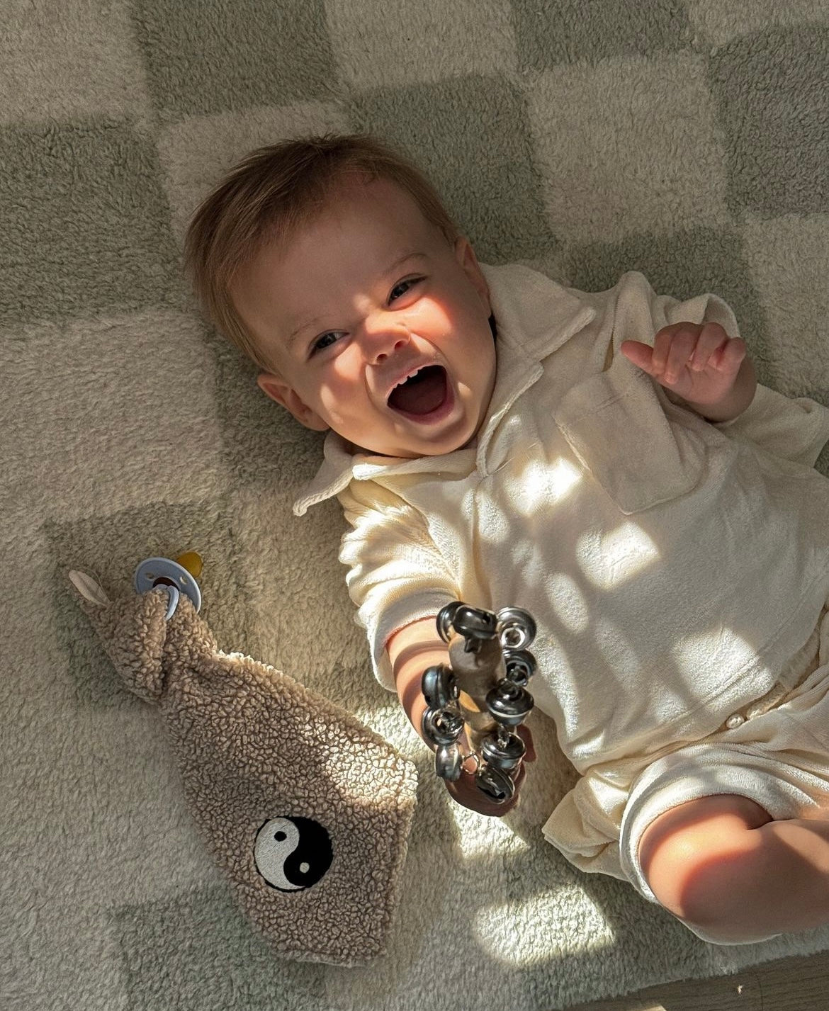 baby met speendoekje van teddy stof met een yin yang icoontje erop 