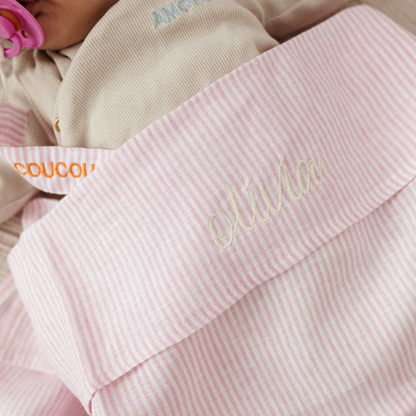 baby ligt onder laken met gepersonaliseerde tekst , speenkoord