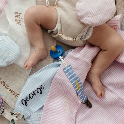 baby ligt op verschillende lakens met tekst. speen met verschillende speenkoorden