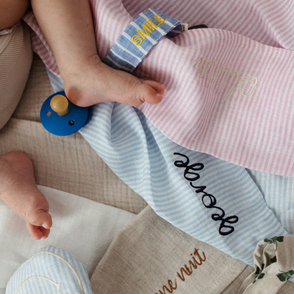 babybeen ligt verschillende lakens met tekst. speen met speenkoord