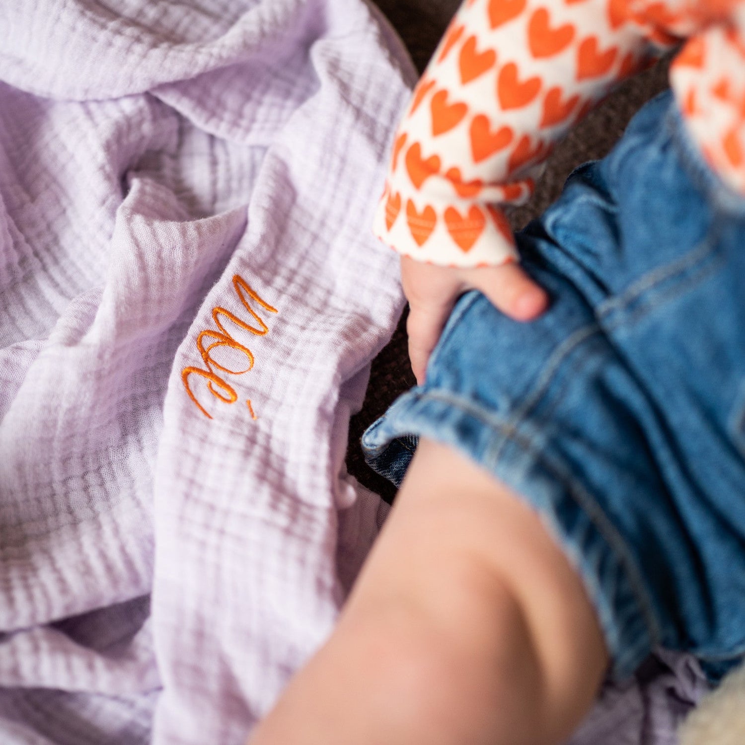 baby zit op lila laken met tekst. 