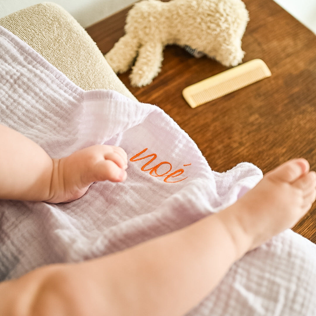 baby ligt op lila laken 