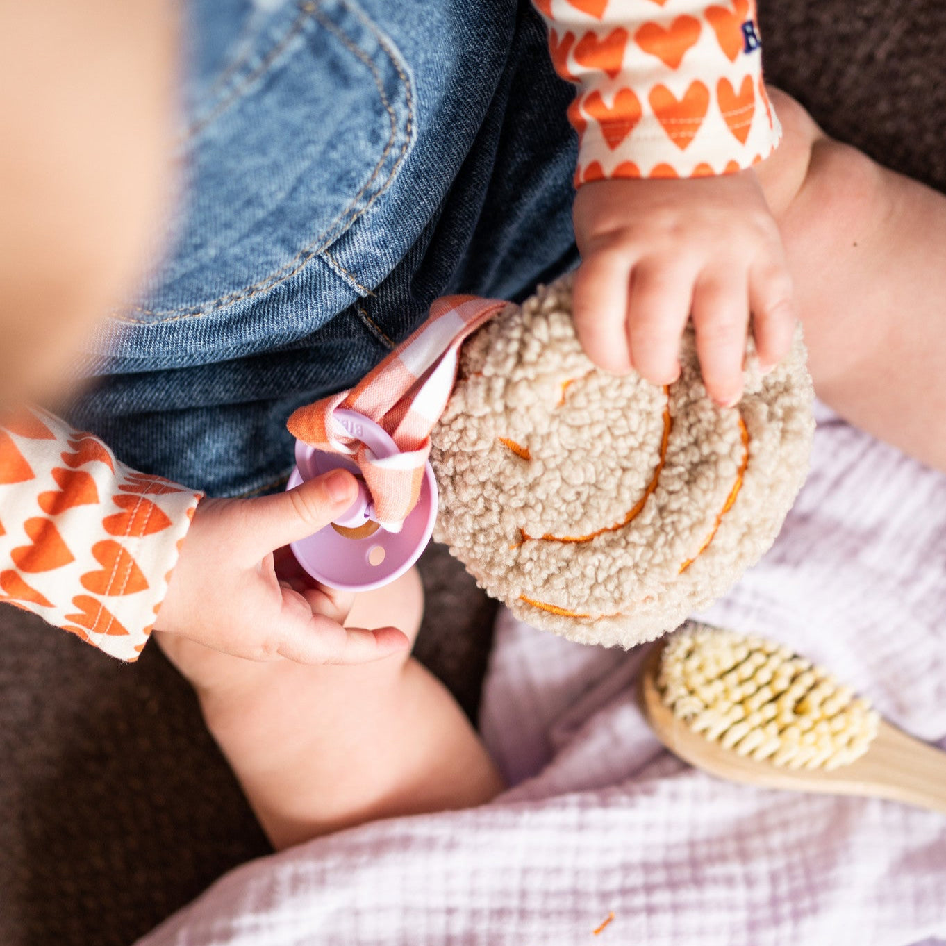 baby met lila laken, borstel en speen met speenknuffel