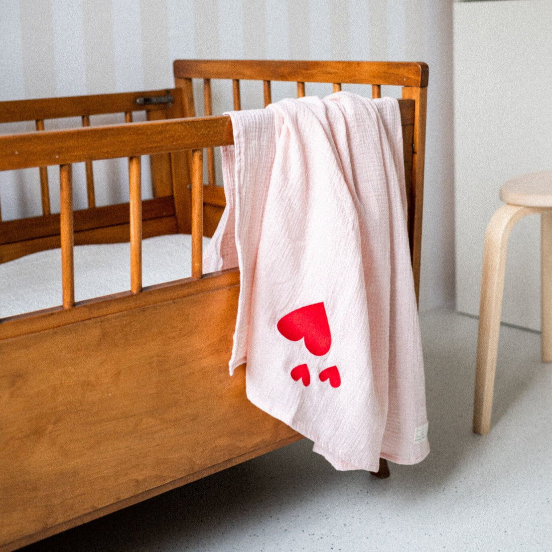 roze hydrofiele doek met icoon ligt over ledikant. 