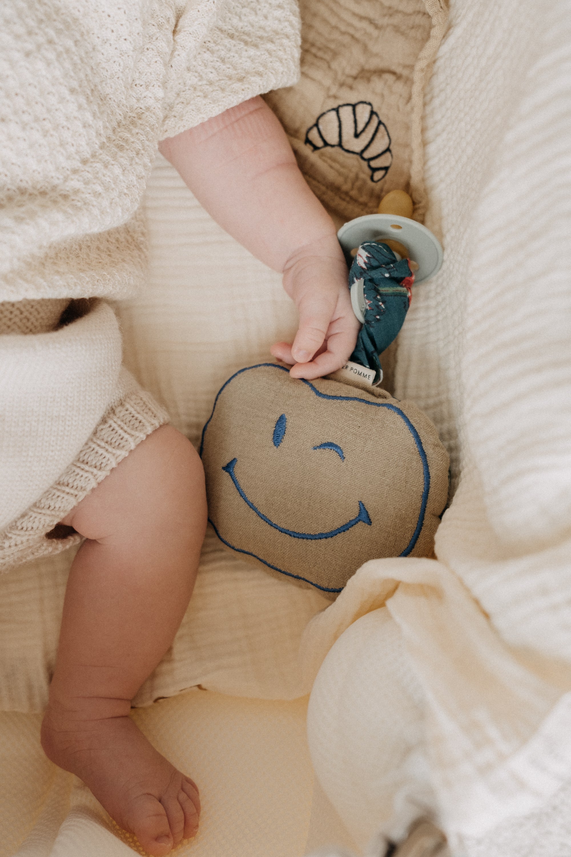 Smiley knuffel speenkoord van zachte wollen stof, met een koord om een speen aan te bevestigen.