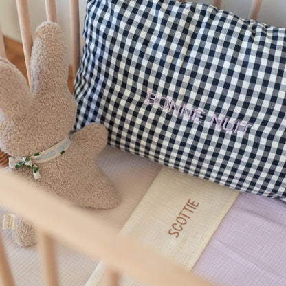knuffel, kussen en paars muslin doek ik ledikant