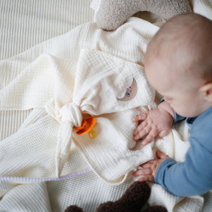 baby met speen en speenkoord van zacht katoen