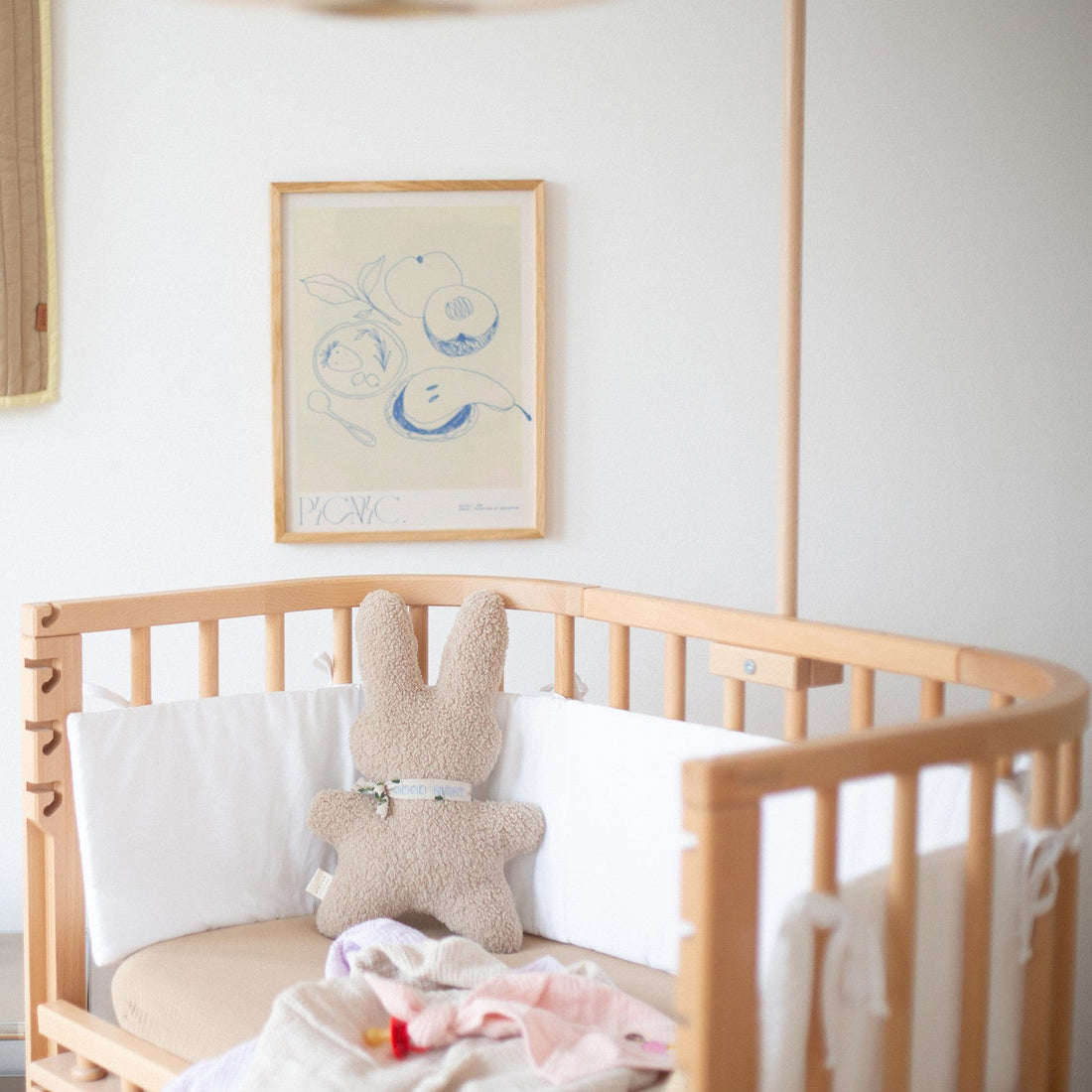 kinderkamer met kinderbedje met daarop een speen met speendoekje in het roze