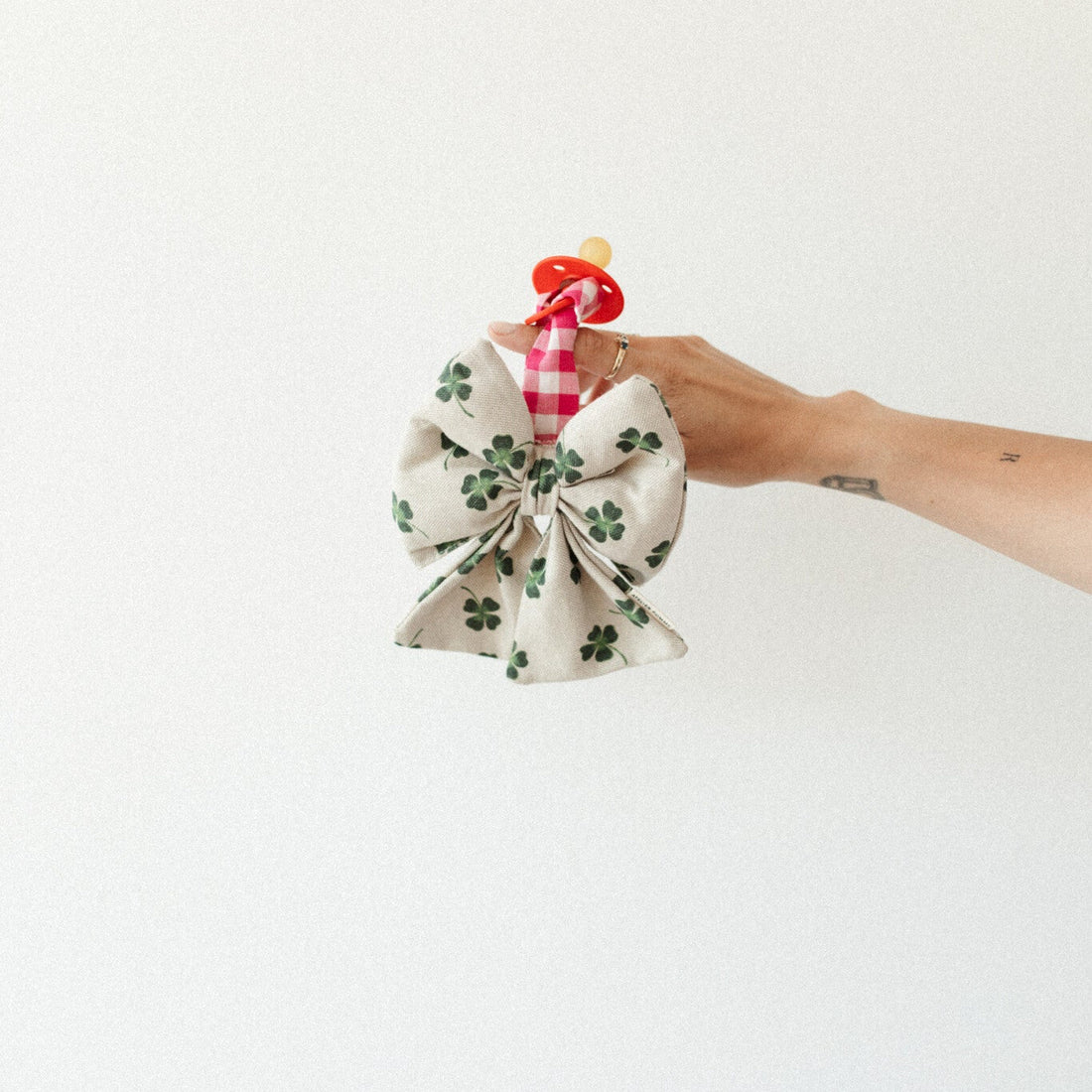 speen met speenknuffel vastgehouden in hand