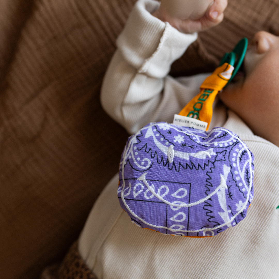 liggende baby met speen in de mond met daaraan een speendoekje. 