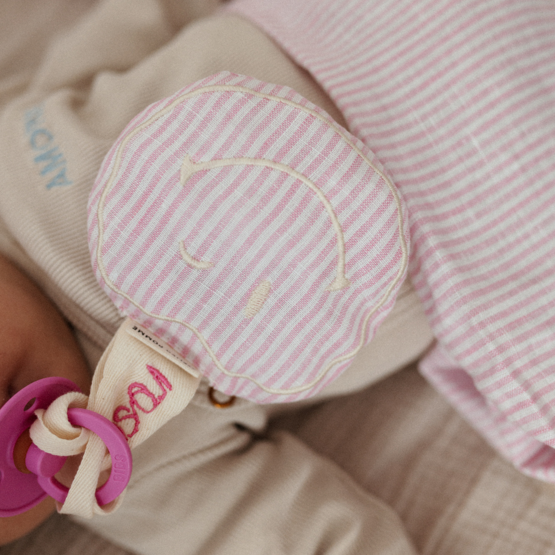 Roze met wit linnen speenkoord met een witte smiley knuffel
