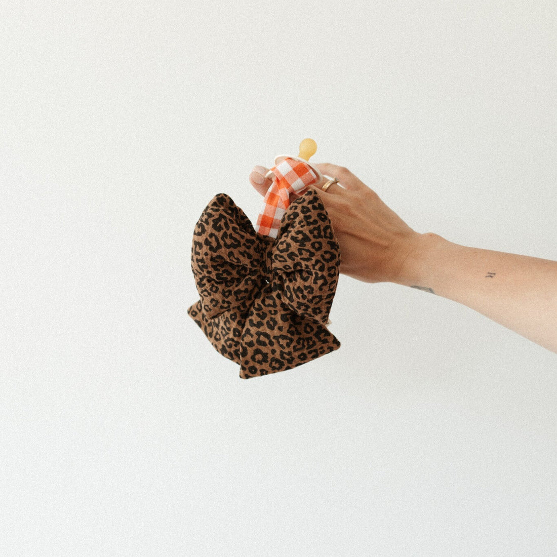 speen en speenknuffel vastgehouden in hand 