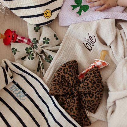 kinderhandjes, lakens, slabber, spenen met speenknuffels. 