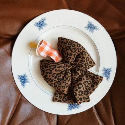 speen met speenknuffel in luipaardprint liggend op een bord. 