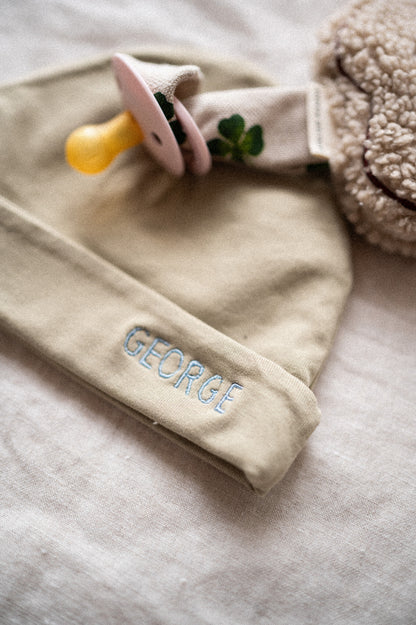 Een speendoekje van teddy met een koord van klavertjes eraan