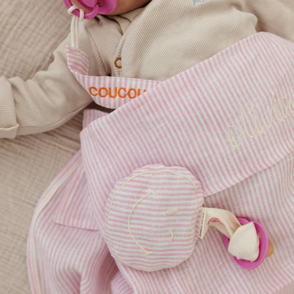 baby ligt onder laken met tekst, spenen met speenknuffel en speenkoord met tekst