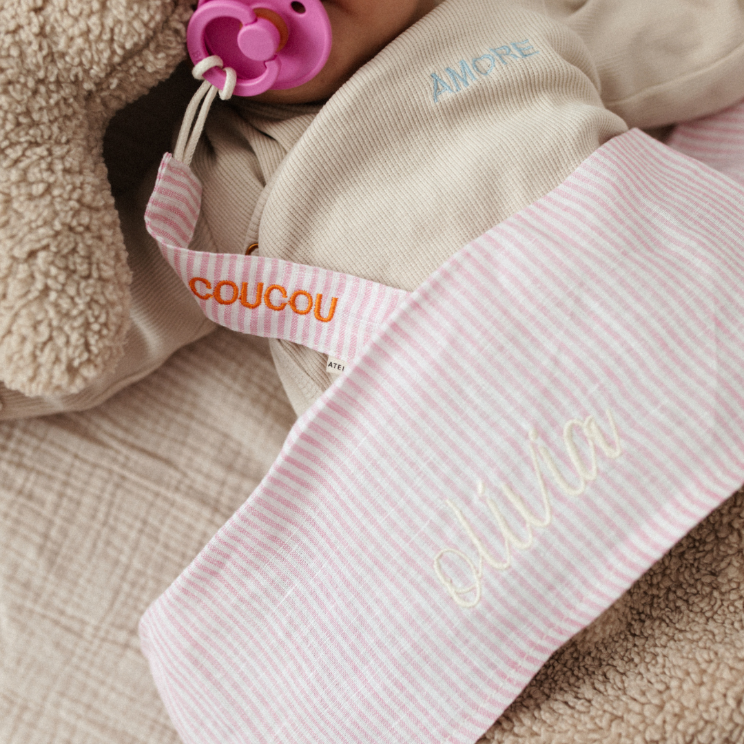 baby ligt onder laken met tekst, knuffel, speen met speenkoord met tekst