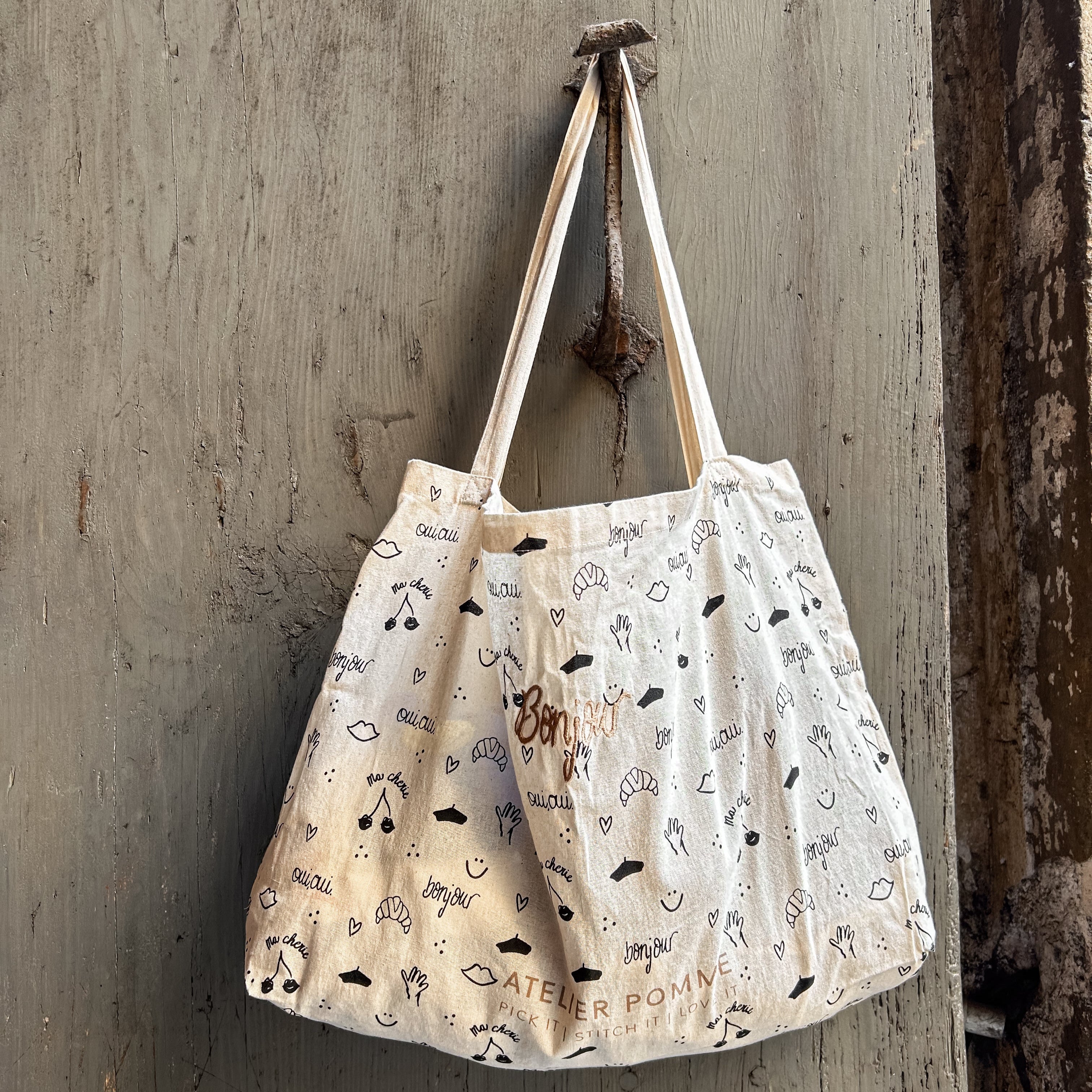 canvas tas met print hangend aan een deurklink 