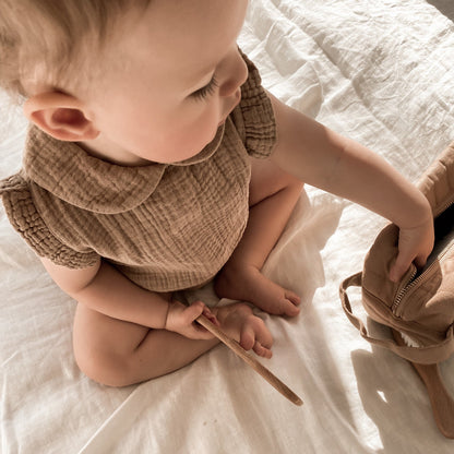 baby draagt bruine romper
