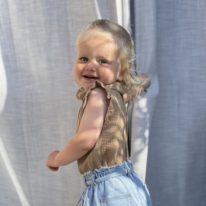 peuter draagt bruine romper