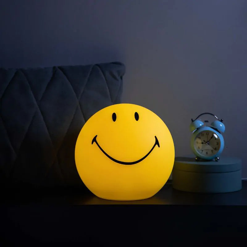 smiley lamp op tafel in donkere ruimte. 