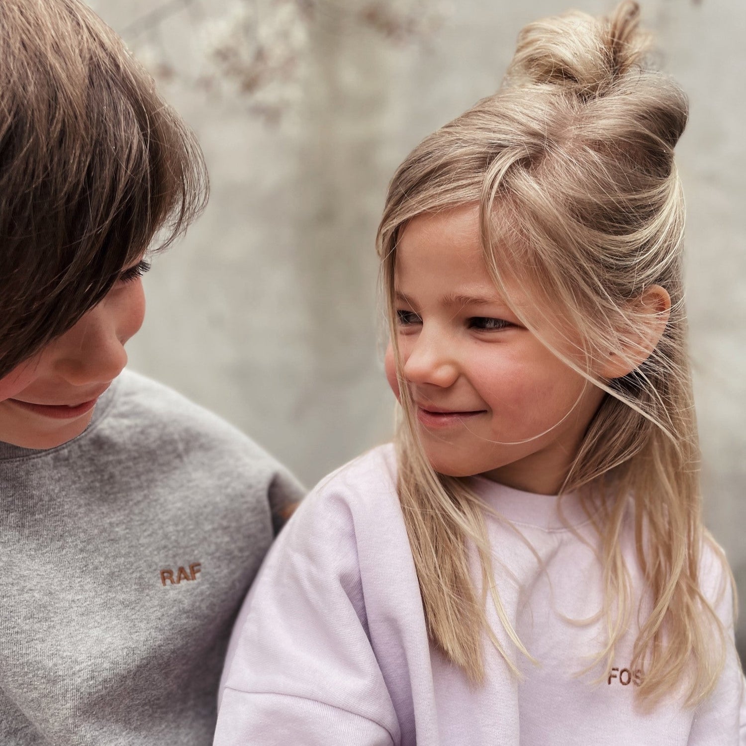 kinderen dragen sweater met tekst. 