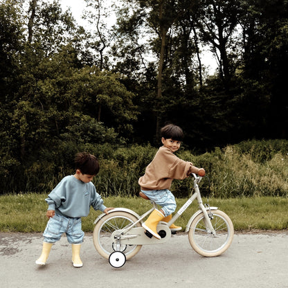 kinderen spelen buiten met een fiets. 