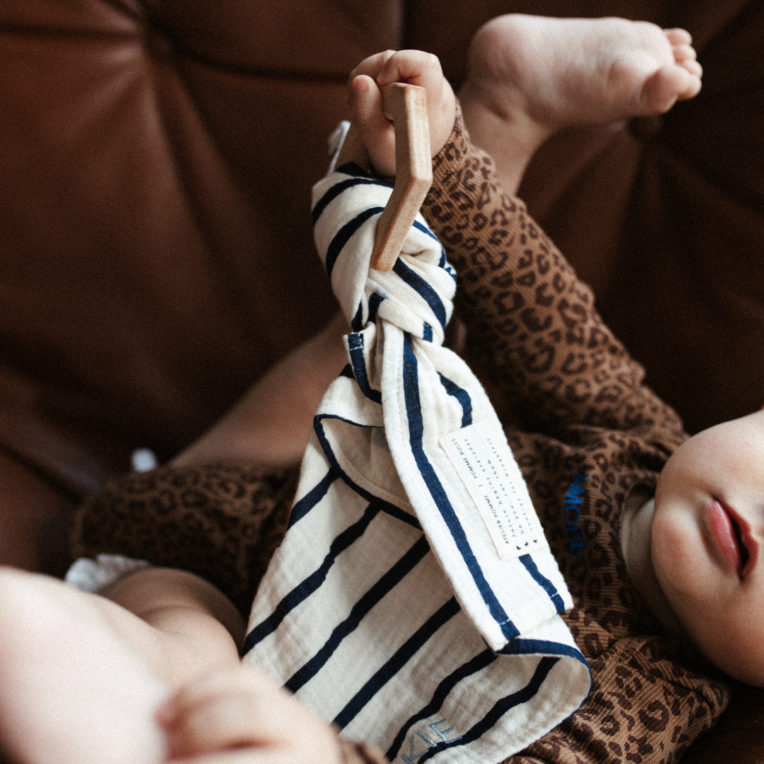 baby houdt bijtring met speendoek vast