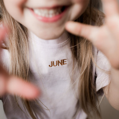 kind draagt T-shirt met gepersonaliseerde tekst. 