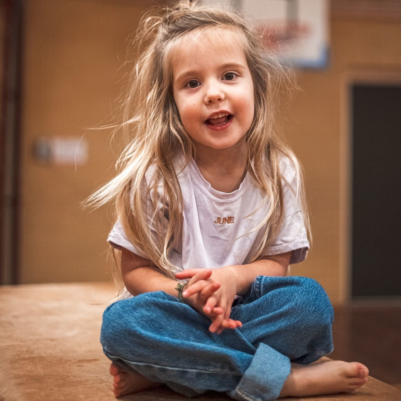 kind draagt lila T-shirt met gepersonaliseerde tekst. 