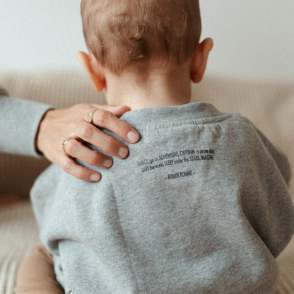 baby draagt grijze sweater. 