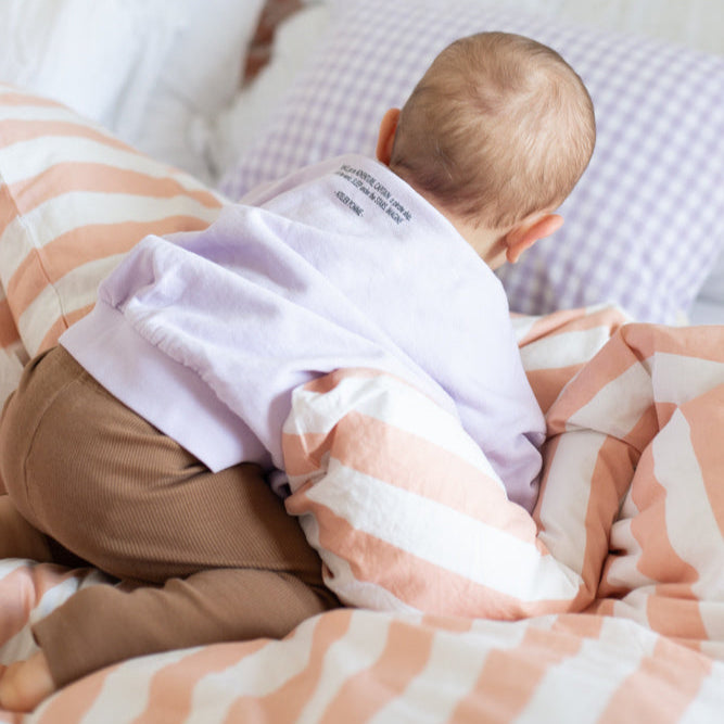 baby draagt lila sweater. 