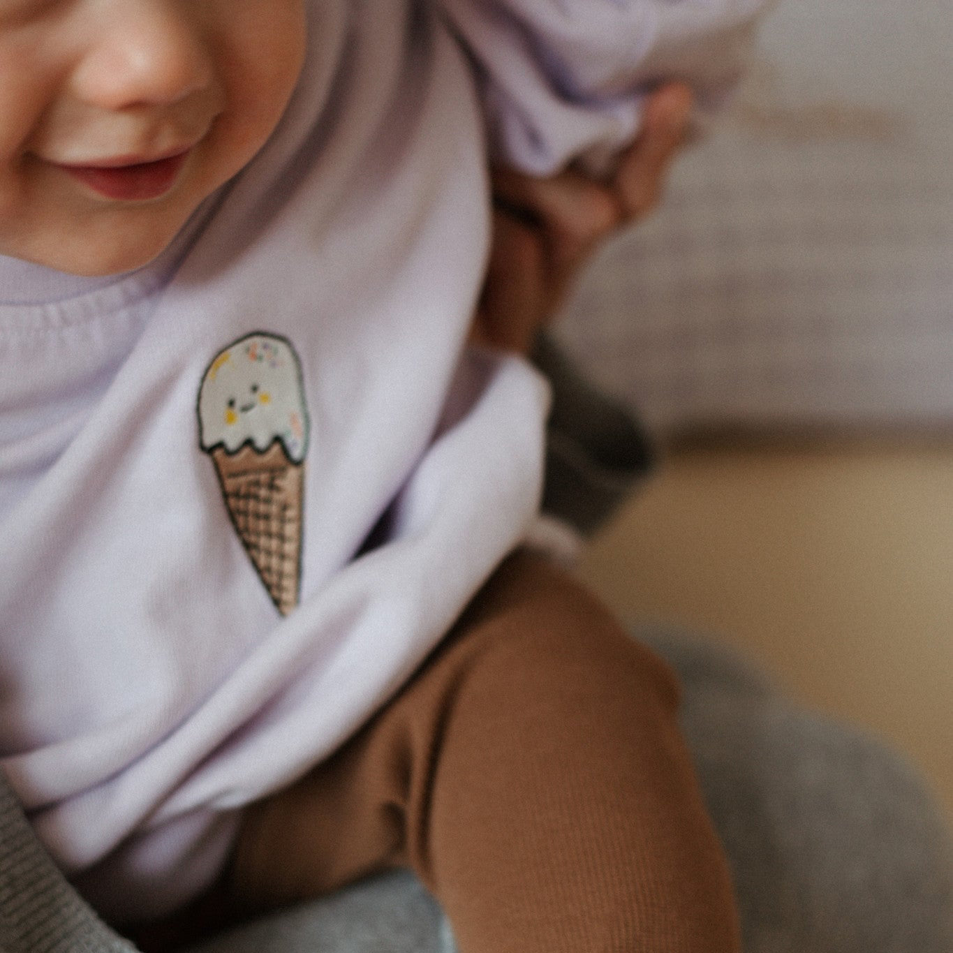 baby draagt lila sweater met icoon. 
