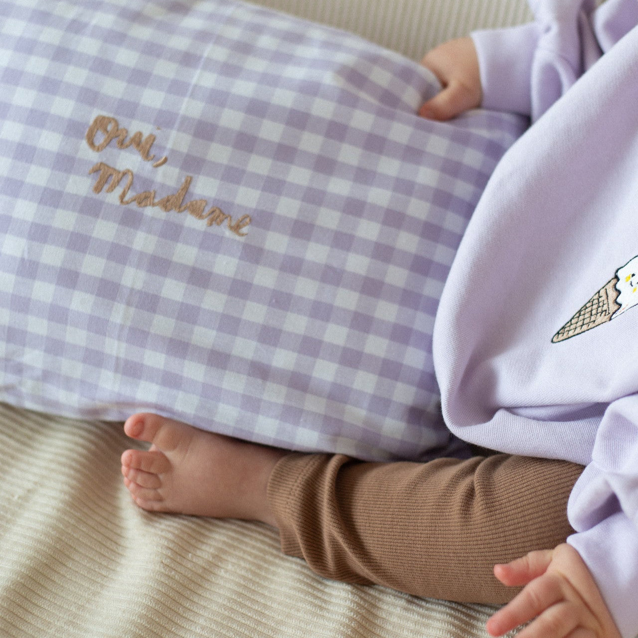 baby draagt lila sweater met icoon. 