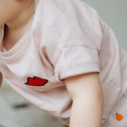 baby draagt roze t-shirt met icoon