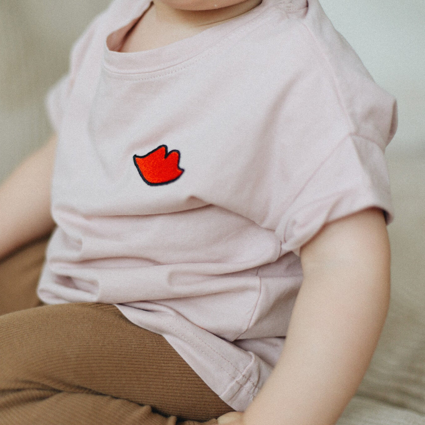 kind draagt roze t-shirt met icoon. 