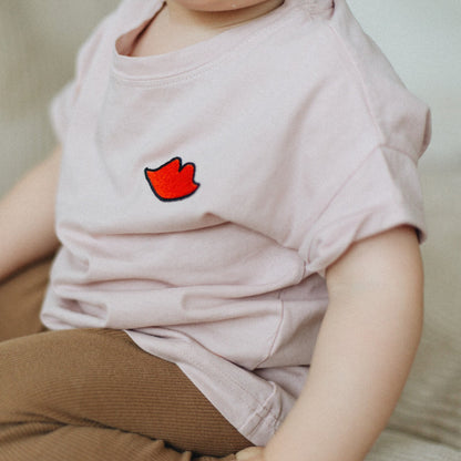 kind draagt roze t-shirt met icoon. 