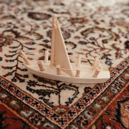 houten speelgoed zeilboot op een vloerkleed