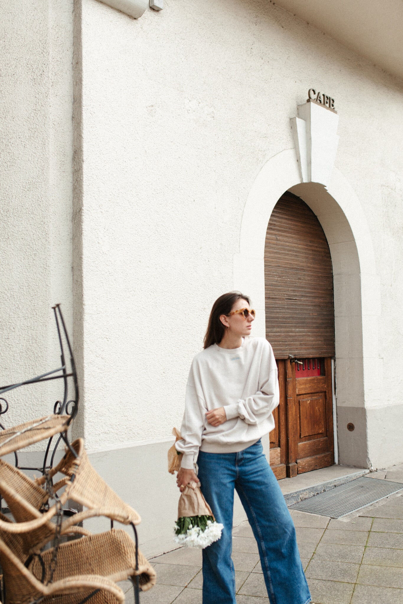 Moeder en vrouw in een oversized beige sweater. Gepersonaliseerd met amore in licht blauw. Gemaakt van 100% biologisch katoen.