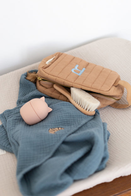 een badlaken en pouch met daarin een borstel voor baby&