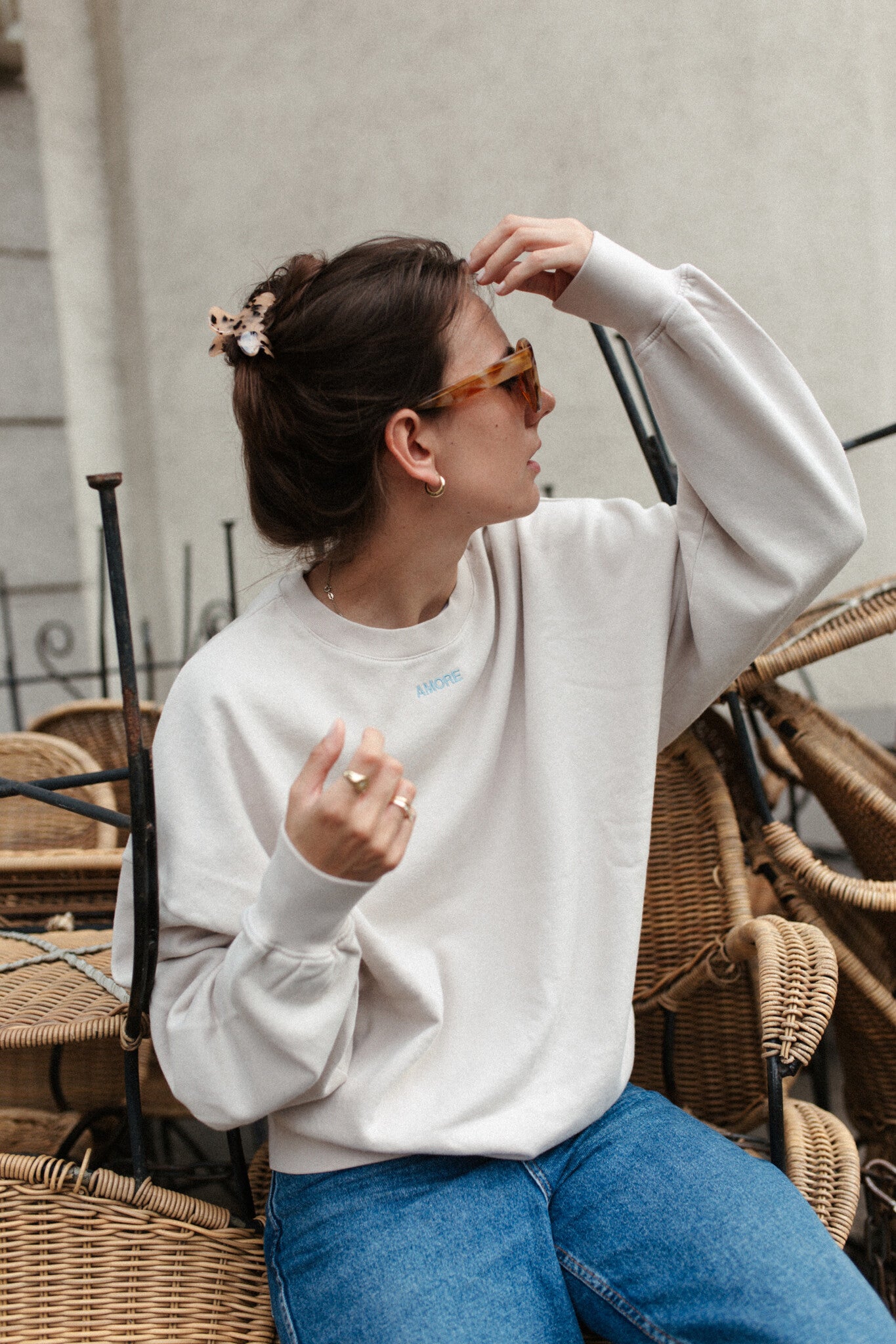 Moeder en vrouw in een oversized beige sweater. Gepersonaliseerd met amore in licht blauw. Gemaakt van 100% biologisch katoen.