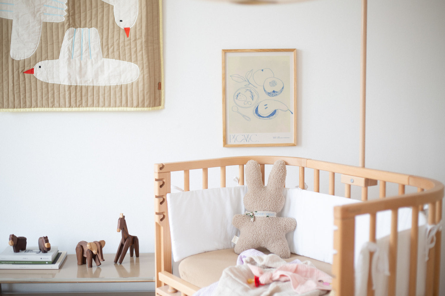 kinderkamer met kinderbedje met daarop een speen met speendoekje in het roze