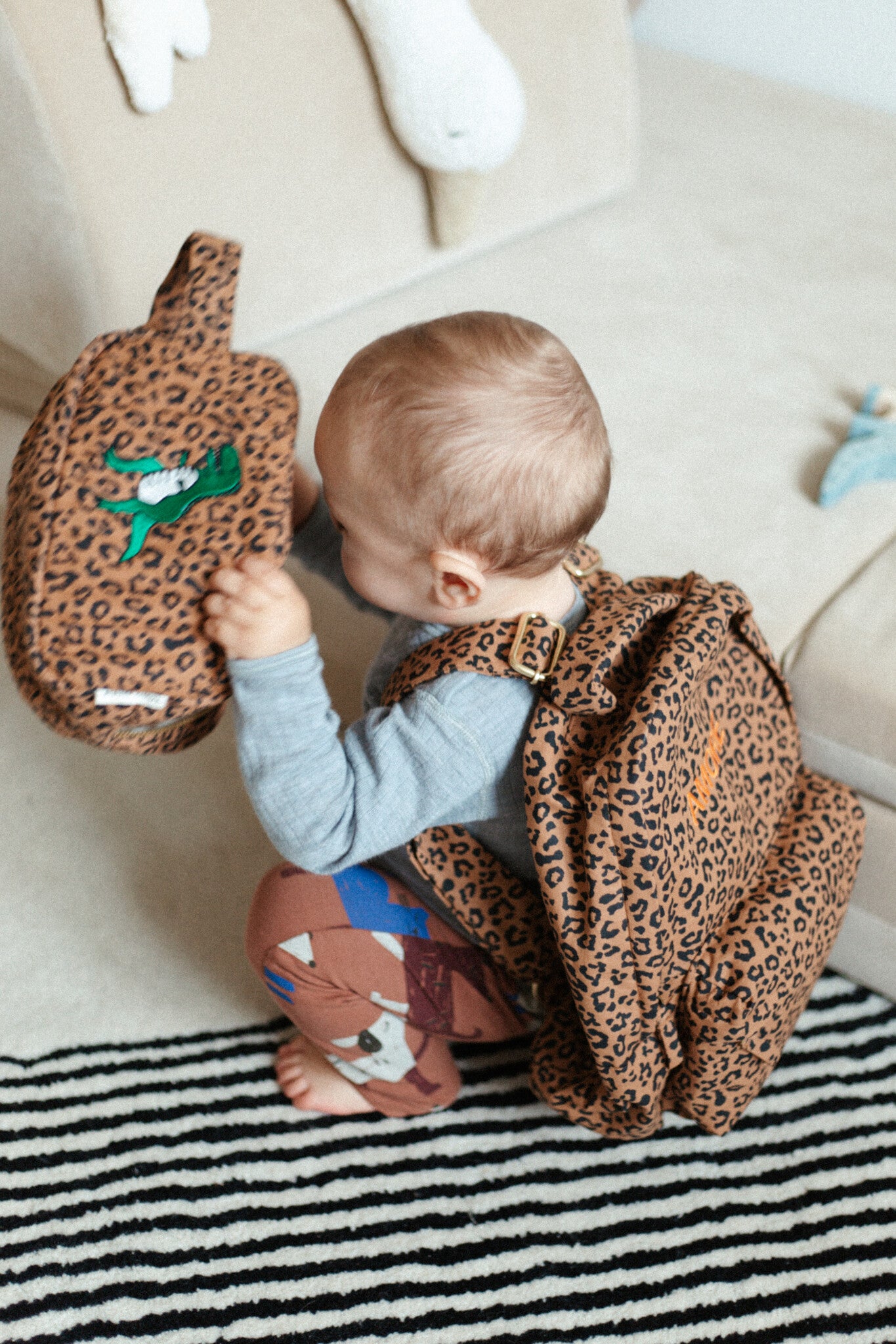 baby met panterprint pouch met leuk dino icon erop gestikt 