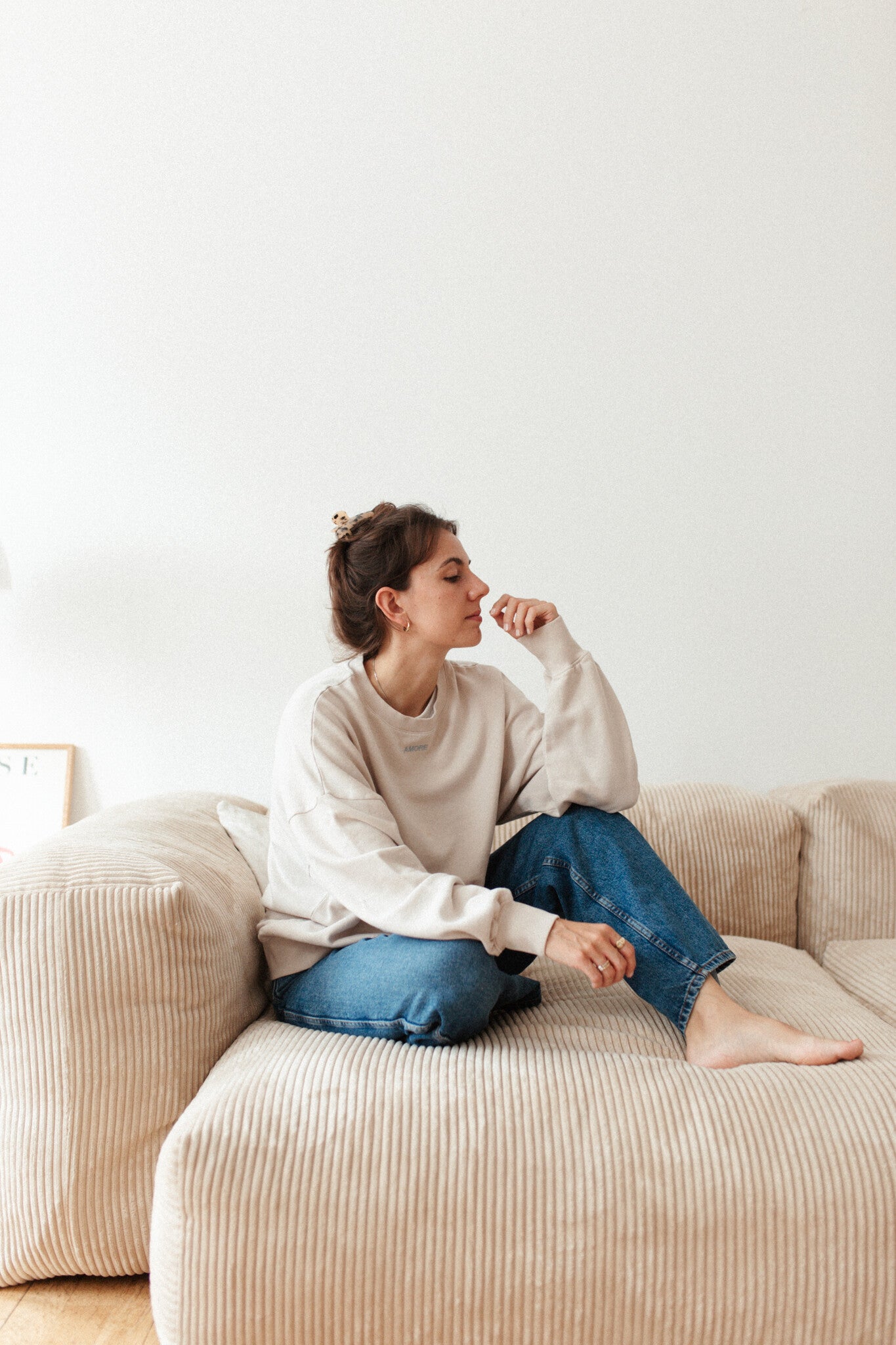 Moeder en vrouw in een oversized beige sweater. Gepersonaliseerd met amore in licht blauw. Gemaakt van 100% biologisch katoen.