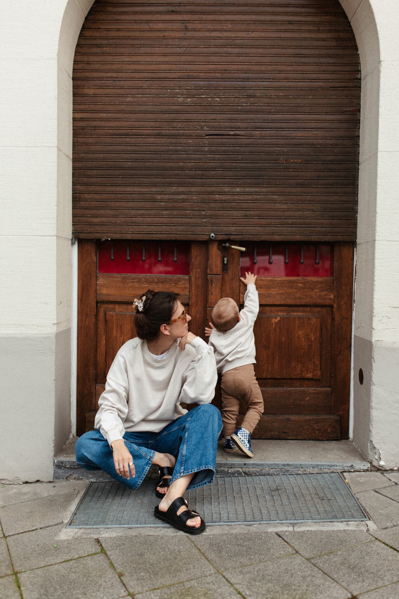 Moeder en kind in een oversized beige sweater. Gepersonaliseerd met amore in licht blauw. Gemaakt van 100% biologisch katoen.